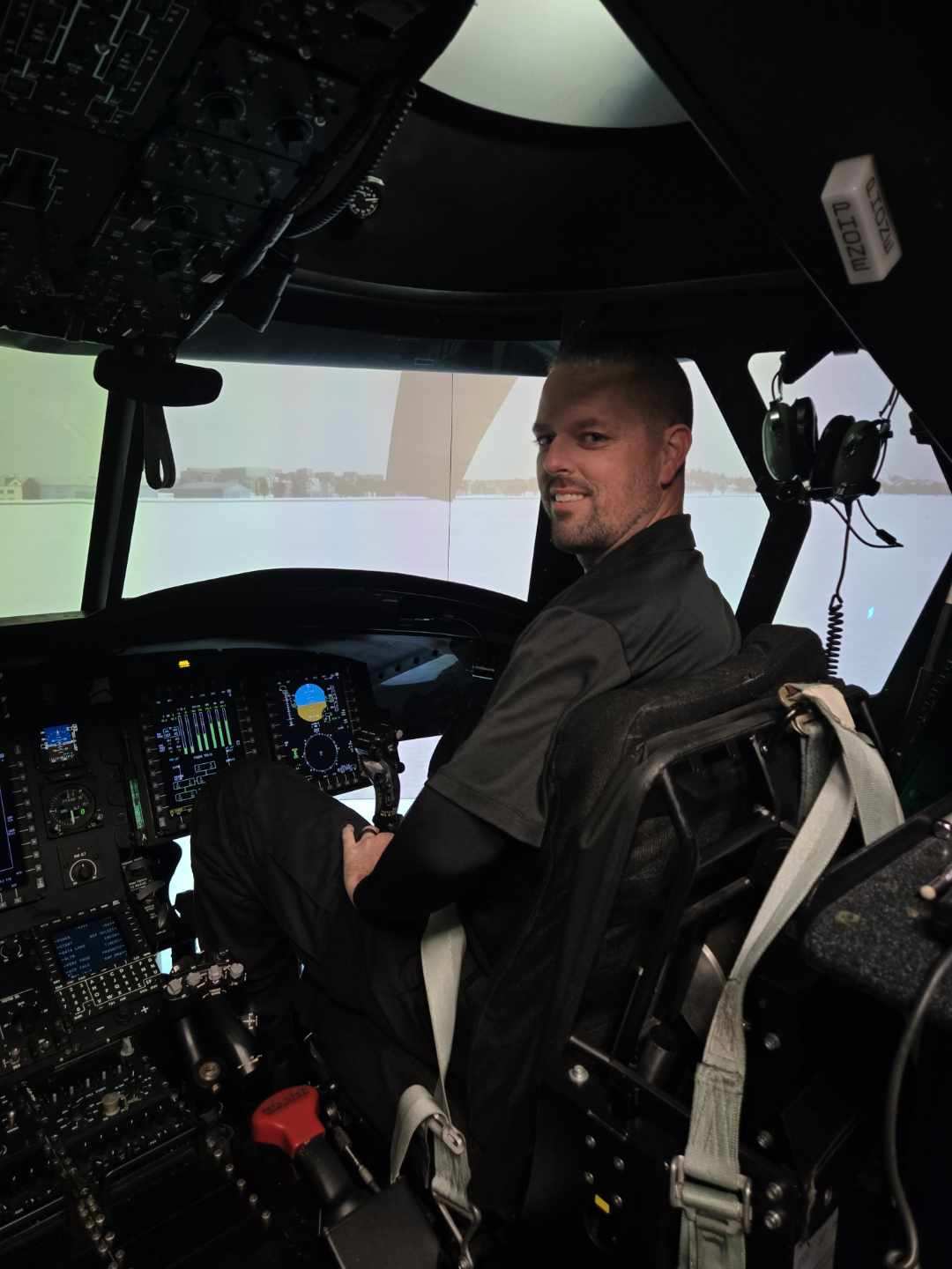 Adam Crowe seated in front of a control panel