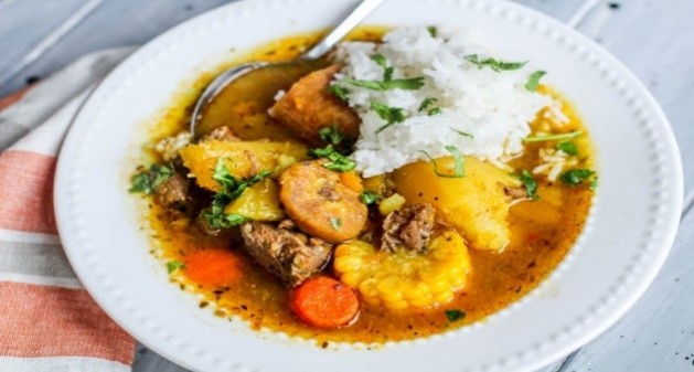 A bowl of stew with rice, meat and vegetables
