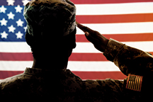 Service member saluting American flag