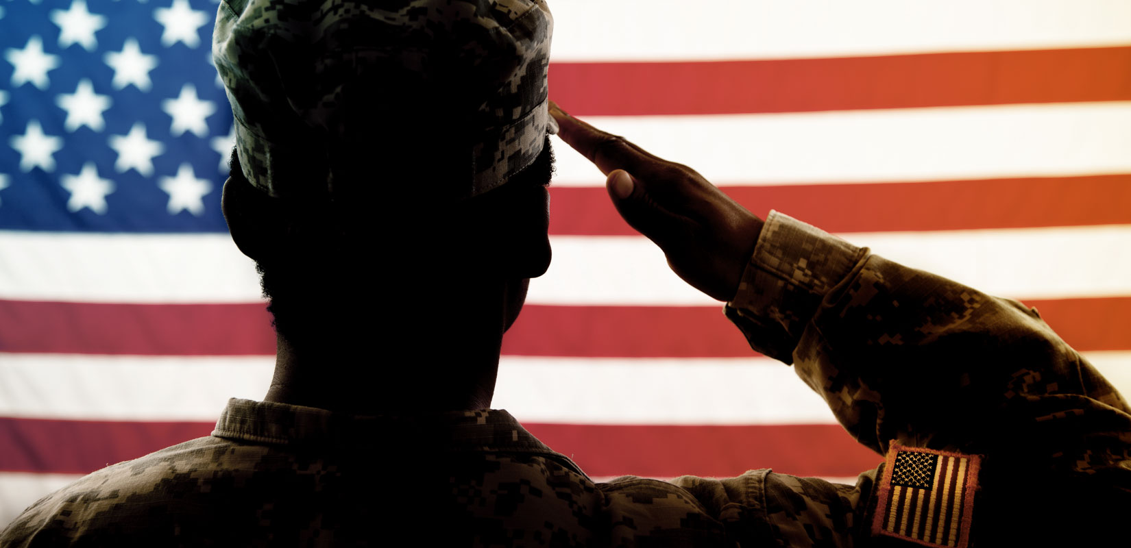 Military Service member saluting flag